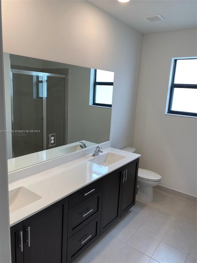 bathroom featuring tile patterned floors, toilet, an enclosed shower, and vanity