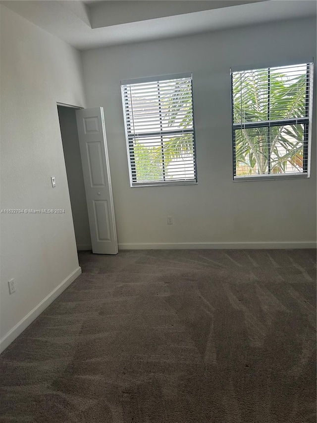 carpeted spare room with baseboards