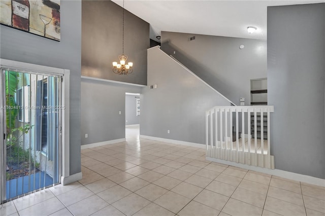 tiled spare room featuring baseboards, visible vents, high vaulted ceiling, and a notable chandelier