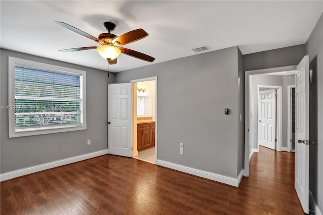 unfurnished bedroom with connected bathroom, wood finished floors, a ceiling fan, visible vents, and baseboards