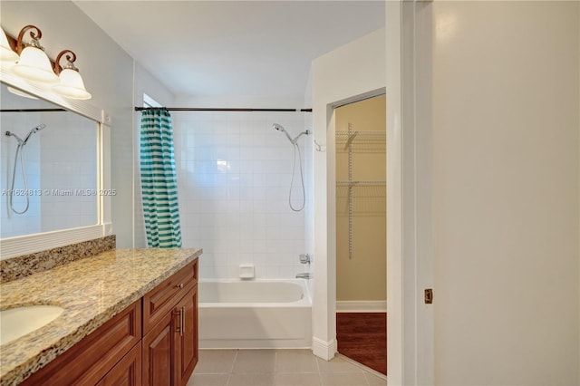 full bath with shower / bath combo, baseboards, tile patterned floors, a spacious closet, and vanity