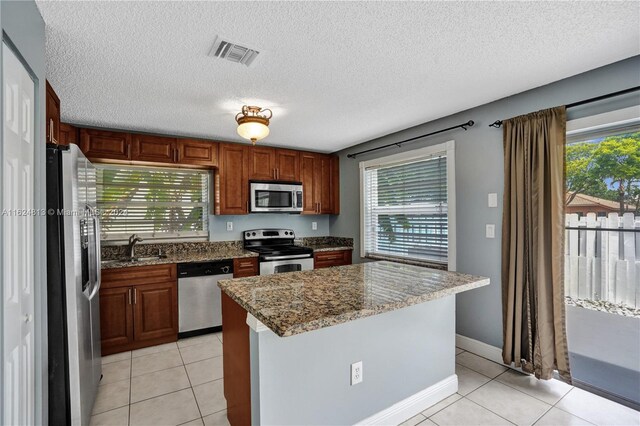 kitchen featuring light tile patterned flooring, stainless steel appliances, and a wealth of natural light