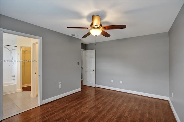 empty room featuring a ceiling fan, baseboards, visible vents, and wood finished floors