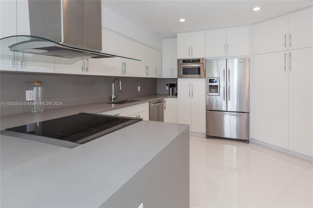 kitchen with appliances with stainless steel finishes, sink, white cabinets, and island exhaust hood