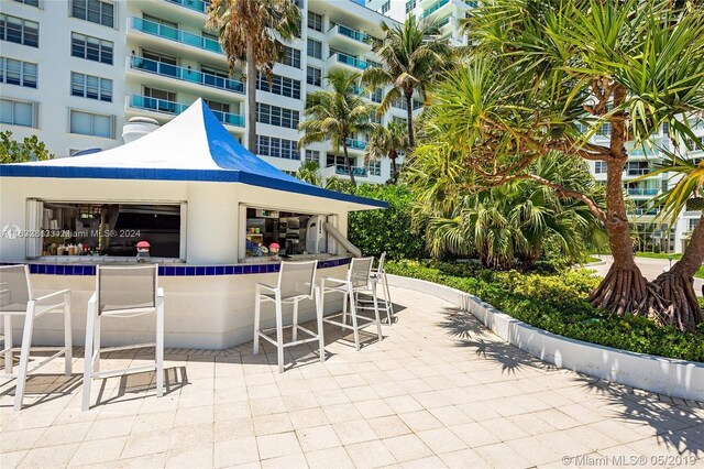 view of patio / terrace featuring a bar and a balcony