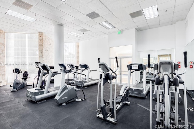 gym featuring a paneled ceiling and a high ceiling