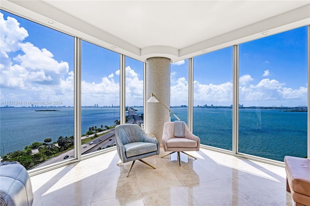 unfurnished sunroom featuring a water view