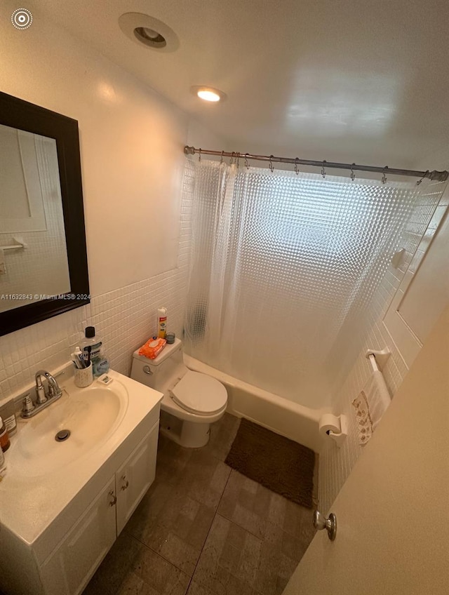 full bathroom with backsplash, shower / bath combo, toilet, tile walls, and vanity