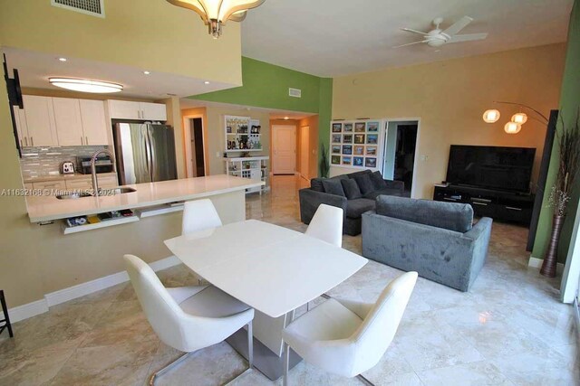 dining room featuring sink, light tile patterned flooring, and ceiling fan