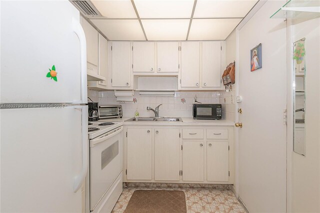 kitchen with light tile patterned flooring, white cabinets, white appliances, sink, and backsplash