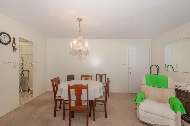 dining area with a notable chandelier and light tile patterned flooring