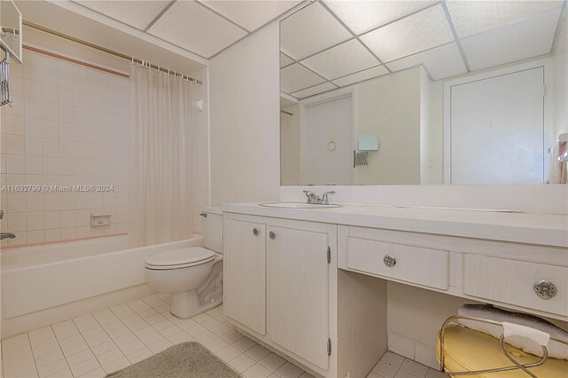 full bathroom featuring vanity, shower / tub combo, a paneled ceiling, toilet, and tile patterned flooring