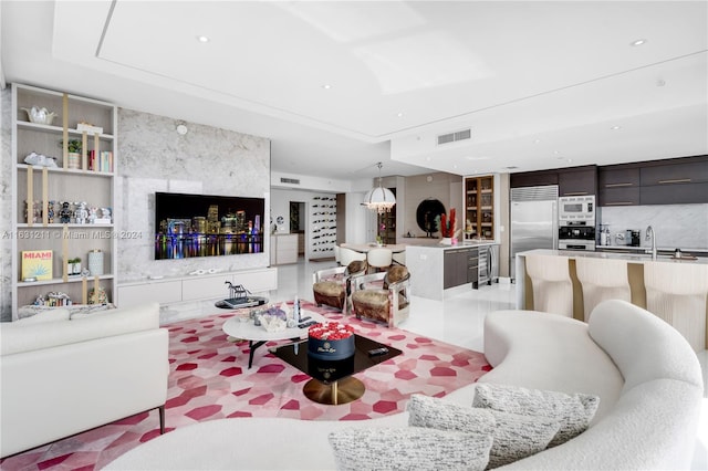 living room with sink, light tile patterned floors, and built in features