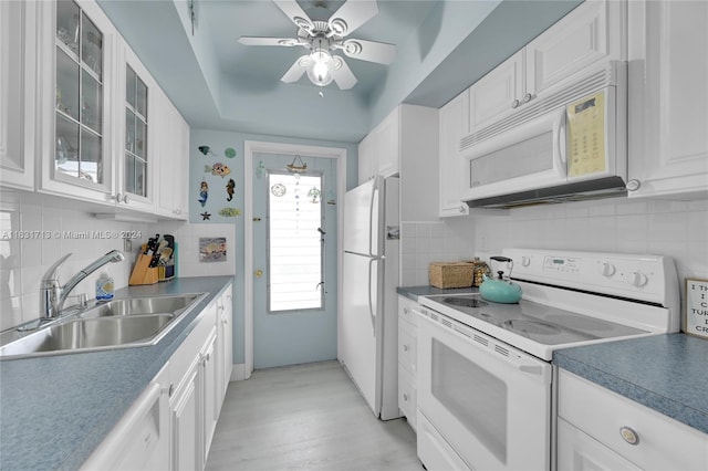 kitchen featuring white cabinets, light wood-type flooring, white appliances, and sink