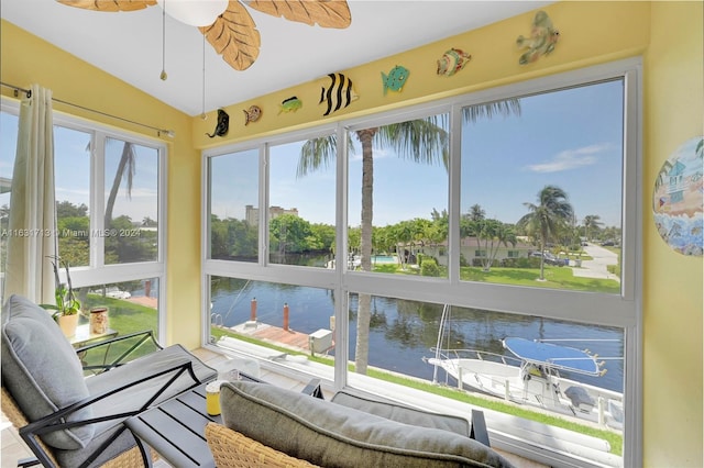 sunroom / solarium with ceiling fan, a water view, and lofted ceiling