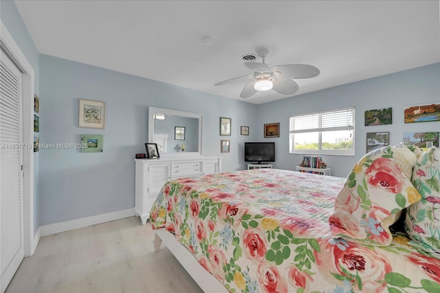 bedroom featuring light wood-style floors, ceiling fan, a closet, and baseboards