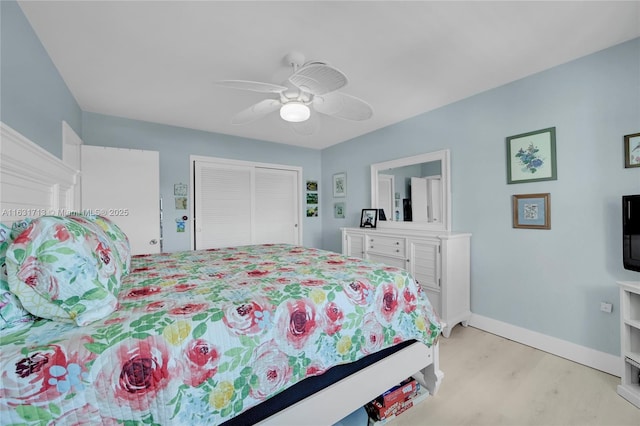 bedroom with light wood-style floors, a closet, baseboards, and ceiling fan
