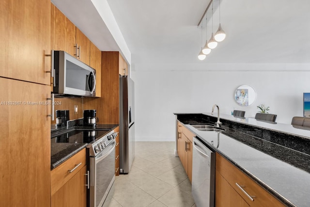 kitchen featuring appliances with stainless steel finishes, light tile patterned floors, sink, and dark stone counters