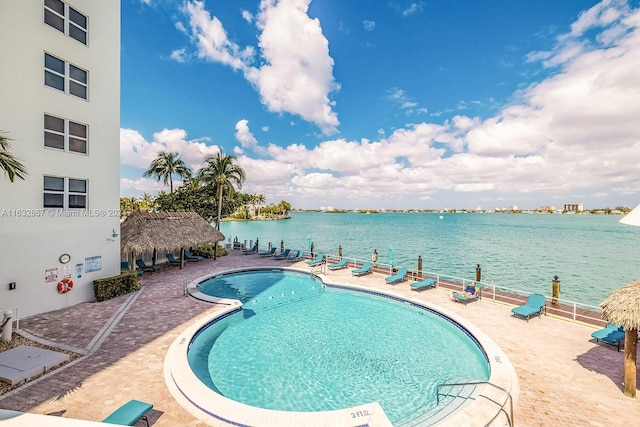 view of swimming pool featuring a patio, a water view, and a gazebo