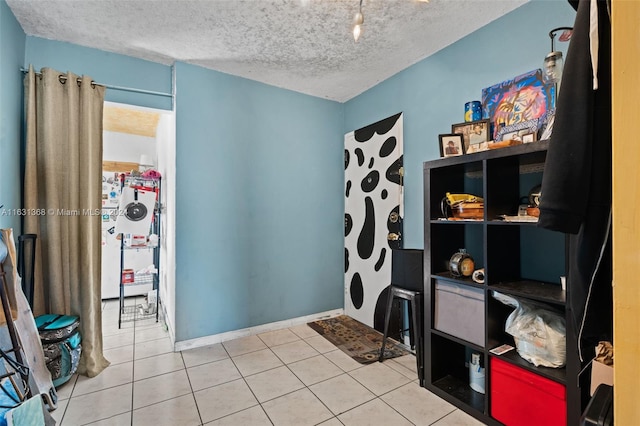 interior space featuring light tile patterned flooring and a textured ceiling