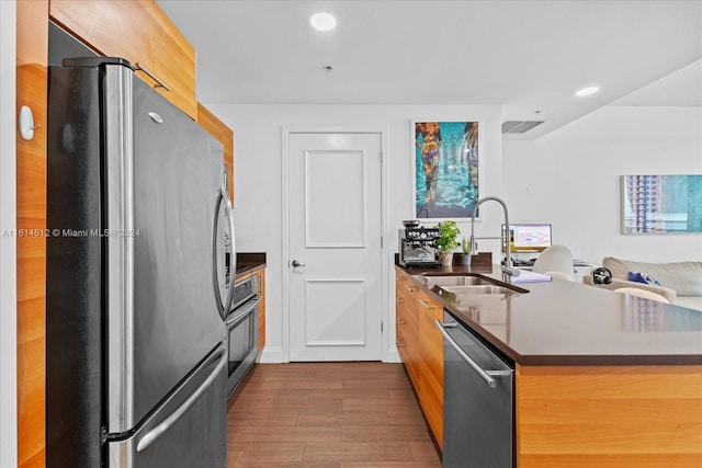 kitchen featuring hardwood / wood-style flooring, appliances with stainless steel finishes, and sink