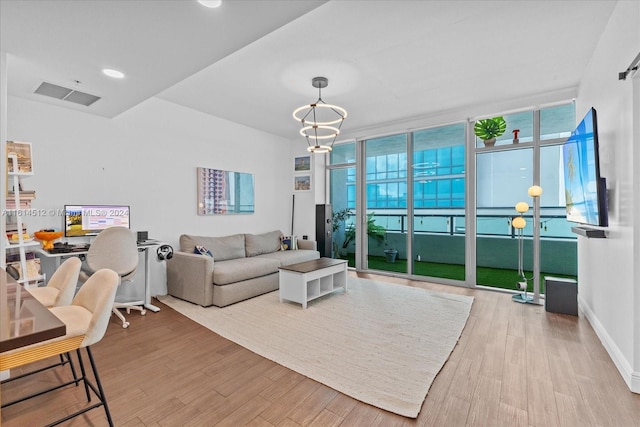 living room featuring hardwood / wood-style flooring, floor to ceiling windows, and a notable chandelier