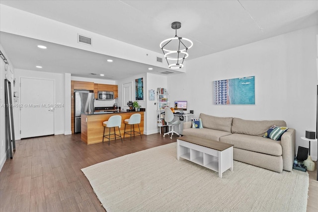 living room with hardwood / wood-style floors and a notable chandelier