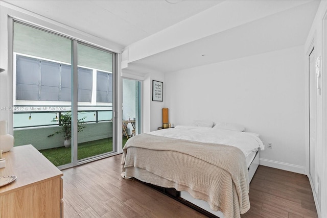 bedroom with hardwood / wood-style flooring, floor to ceiling windows, and access to outside