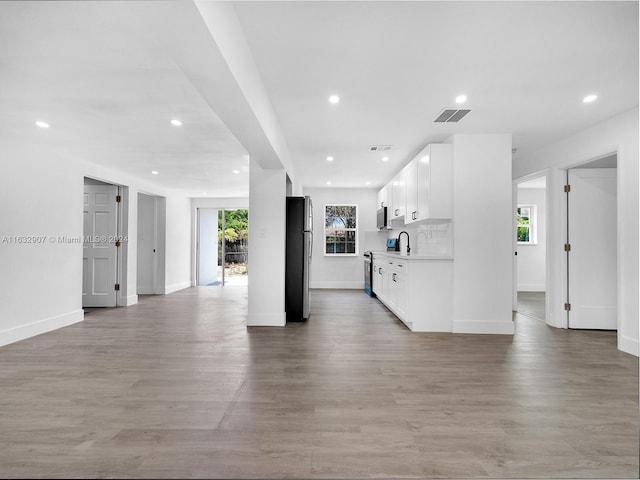 unfurnished living room with a healthy amount of sunlight and light wood-type flooring