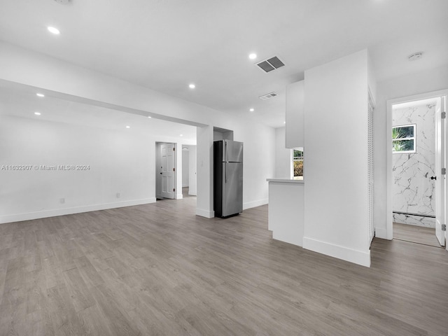 unfurnished living room featuring a healthy amount of sunlight and hardwood / wood-style floors