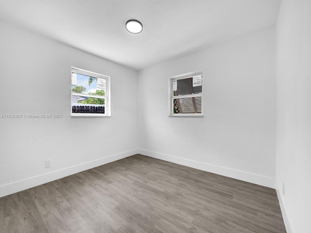 unfurnished room with dark hardwood / wood-style flooring