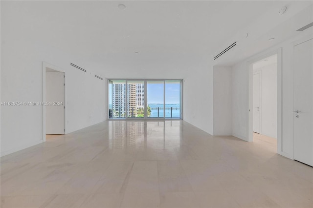 tiled empty room with floor to ceiling windows