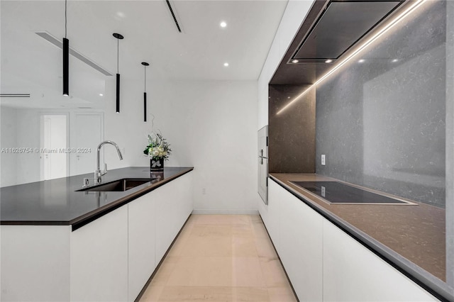 kitchen with sink, white cabinets, decorative light fixtures, and light tile patterned floors