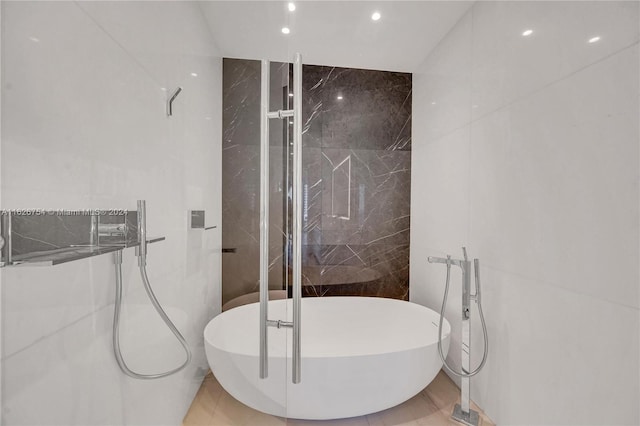 bathroom featuring tiled shower and tile walls