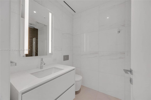 bathroom featuring vanity, toilet, tile walls, and tile patterned flooring