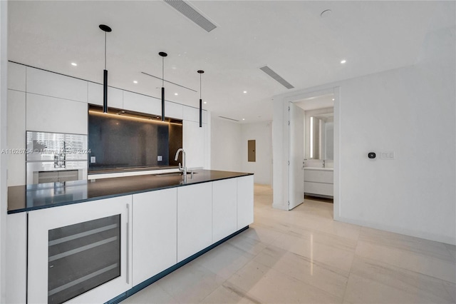 kitchen with hanging light fixtures, white cabinets, light tile patterned floors, and wine cooler