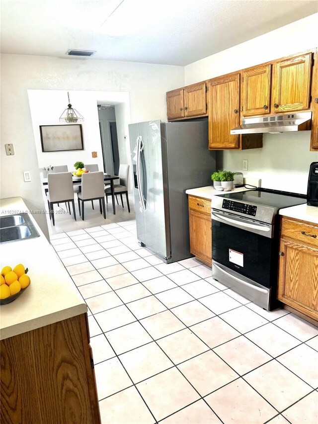 kitchen with stainless steel fridge, sink, range, and light tile patterned floors