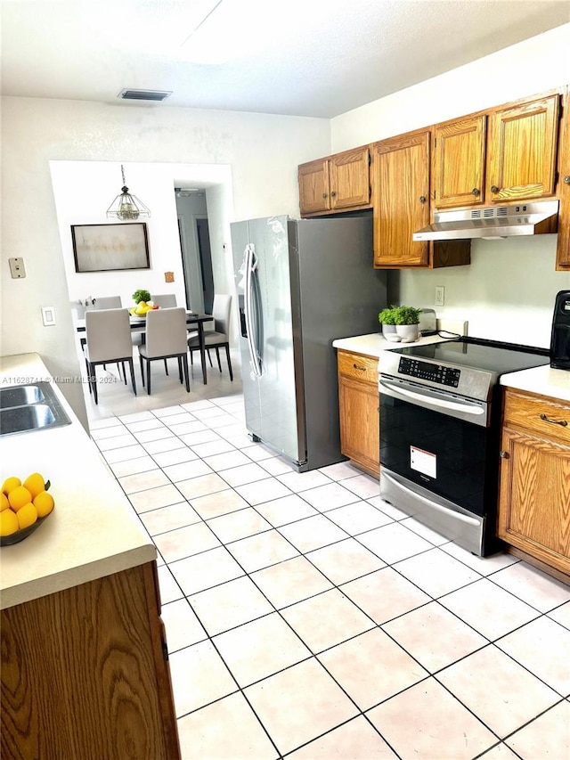 kitchen featuring under cabinet range hood, visible vents, light countertops, appliances with stainless steel finishes, and brown cabinets