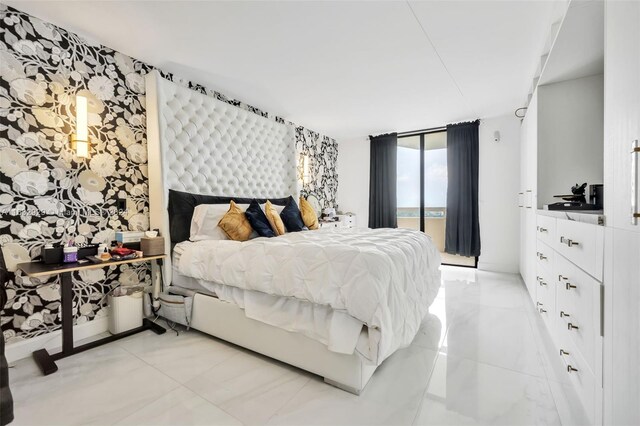 tiled bedroom featuring floor to ceiling windows, a water view, and access to exterior