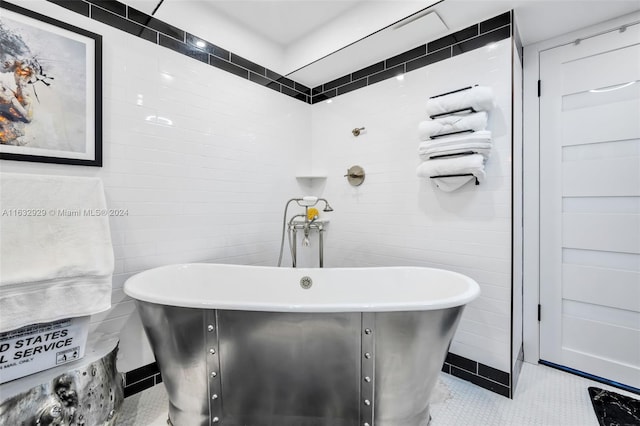 bathroom featuring tile walls, a bath, and tile patterned floors