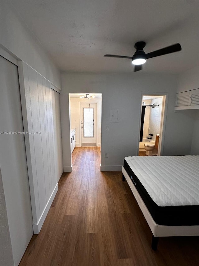 unfurnished bedroom featuring ensuite bathroom, wood-type flooring, and ceiling fan