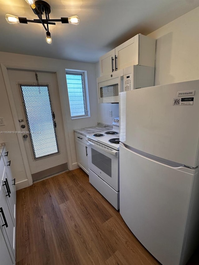 kitchen with dark hardwood / wood-style flooring, white cabinets, and white appliances