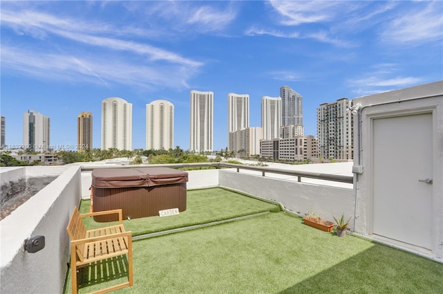 view of yard featuring a hot tub and a balcony