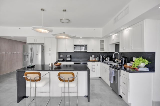 kitchen with pendant lighting, sink, white cabinets, a center island, and stainless steel appliances