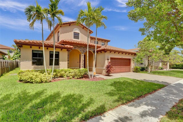 mediterranean / spanish house featuring a front lawn and a garage