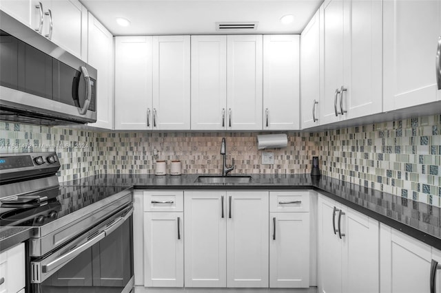 kitchen featuring sink, tasteful backsplash, stainless steel appliances, and white cabinets