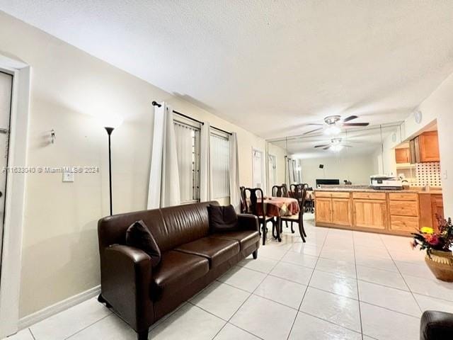 living room featuring light tile patterned floors and ceiling fan