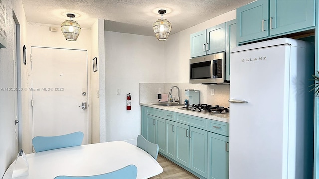 kitchen featuring decorative backsplash, appliances with stainless steel finishes, decorative light fixtures, light countertops, and a sink