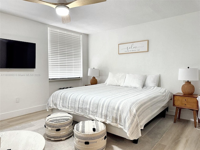 bedroom featuring light wood finished floors, ceiling fan, and baseboards