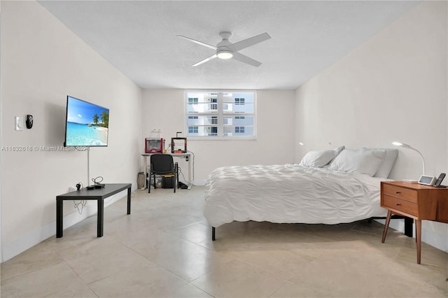 bedroom with ceiling fan and a textured ceiling